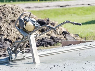 Handheld concrete vibrator tool being used during slab pour
