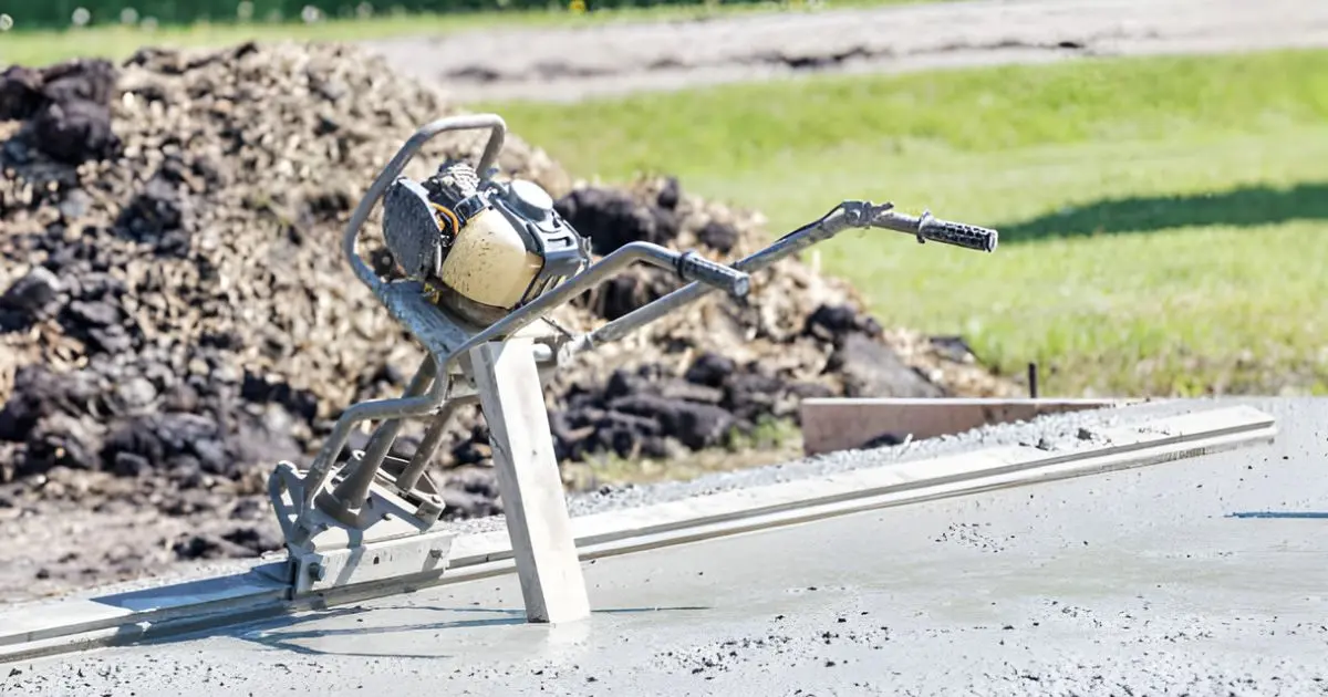 Handheld concrete vibrator tool being used during slab pour
