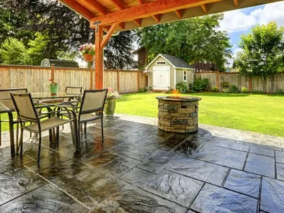 Large stamped concrete patio with outdoor furniture and fire pit