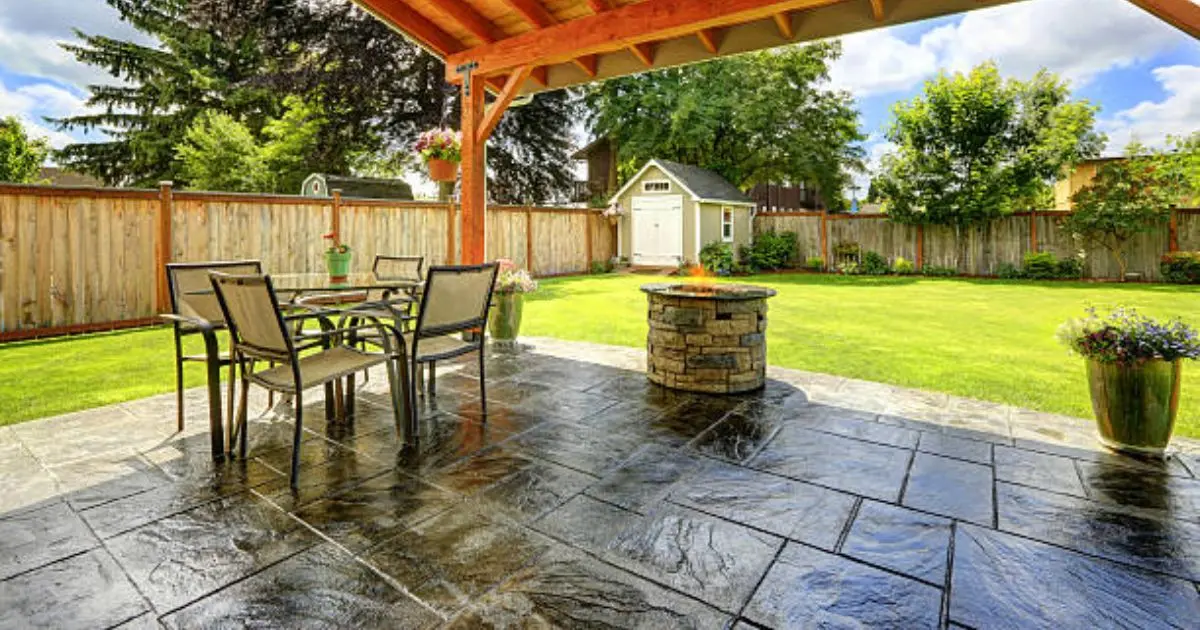Large stamped concrete patio with outdoor furniture and fire pit