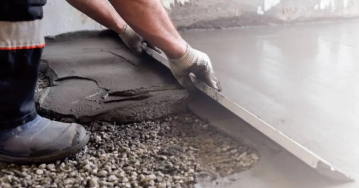 Workers using screed board to level concrete between forms